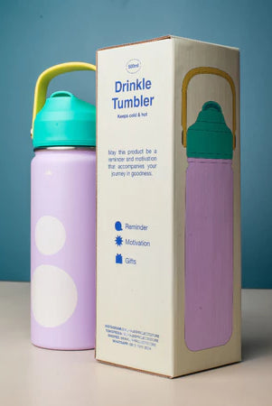Purple tumbler with teal lid next to its packaging on a blue background