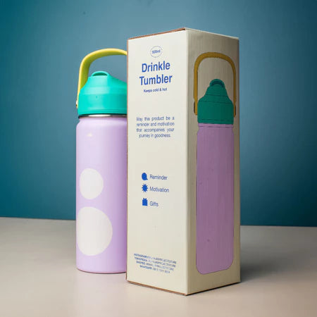 Purple tumbler with teal lid next to its packaging on a blue background