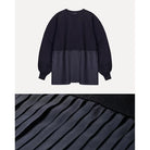 Black pleated top by Maima with a close-up of the pleated texture on a white background