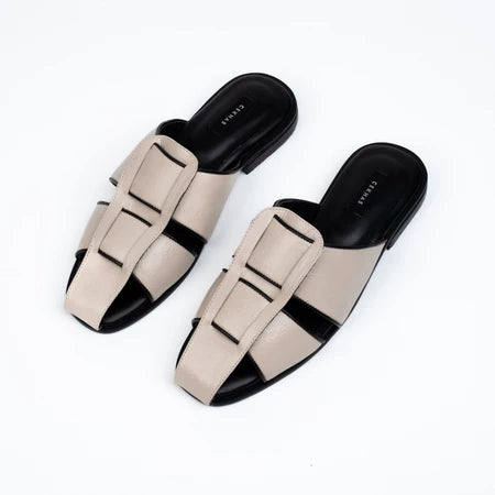 Pair of cream and black mules sandal by Cekhas on a white background