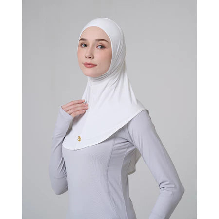 Woman wearing a white hijab sport by Inanna and gray long-sleeve shirt on a light gray background