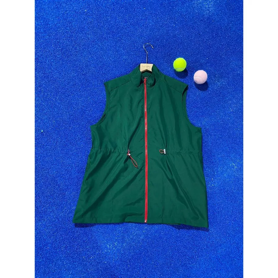 Green vest by Abame with red zipper on a blue textured background