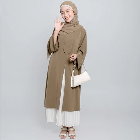 Seorang wanita menggunakan Aletha Tunic berwarna wood, sebuah tunik yang terbuat dari Cotton Bordir premium yang memberikan kenyamanan maksimal, dari Vlowy.