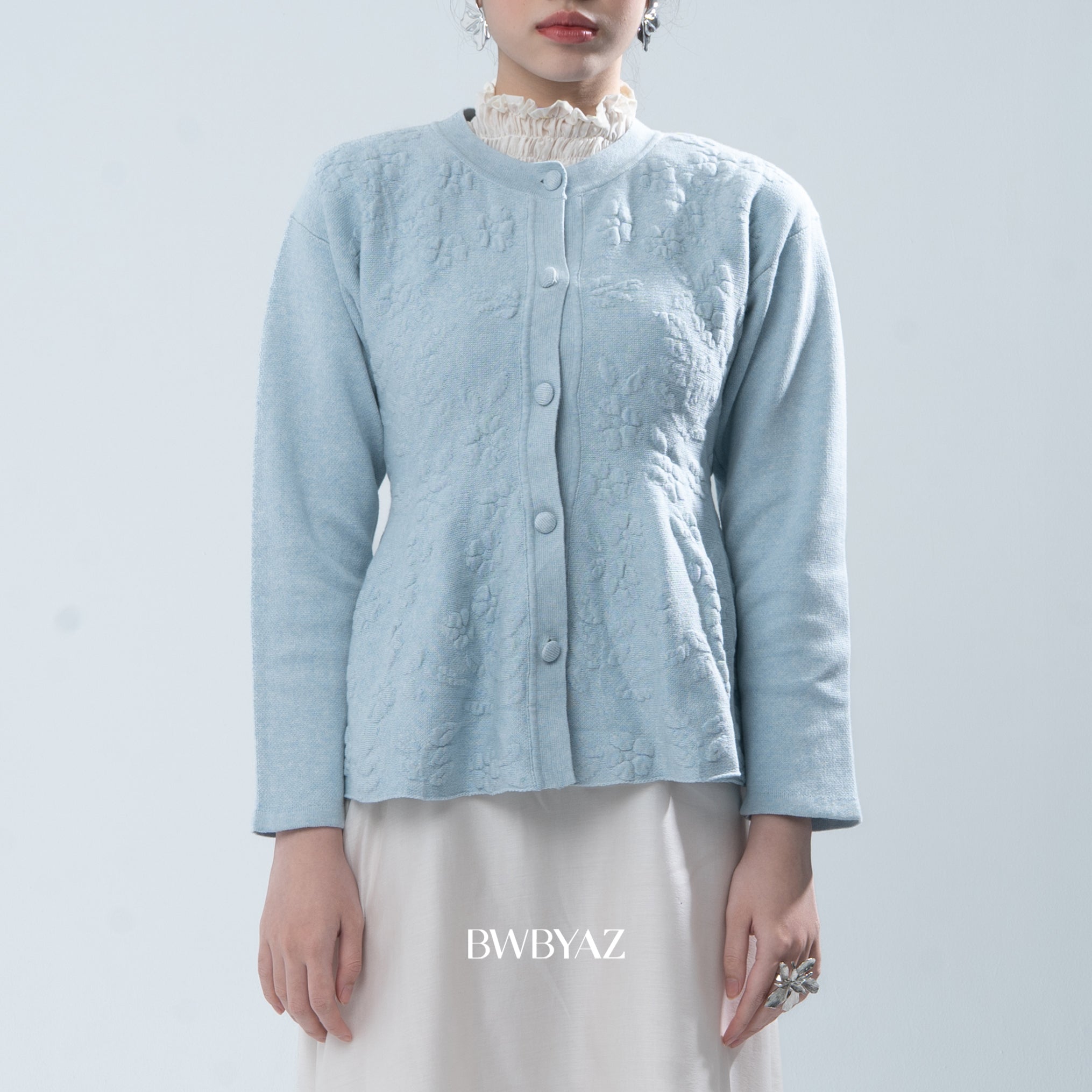 Light blue textured knit cardigan worn by a person on a light gray background, with 'BWBYAZ' branding.