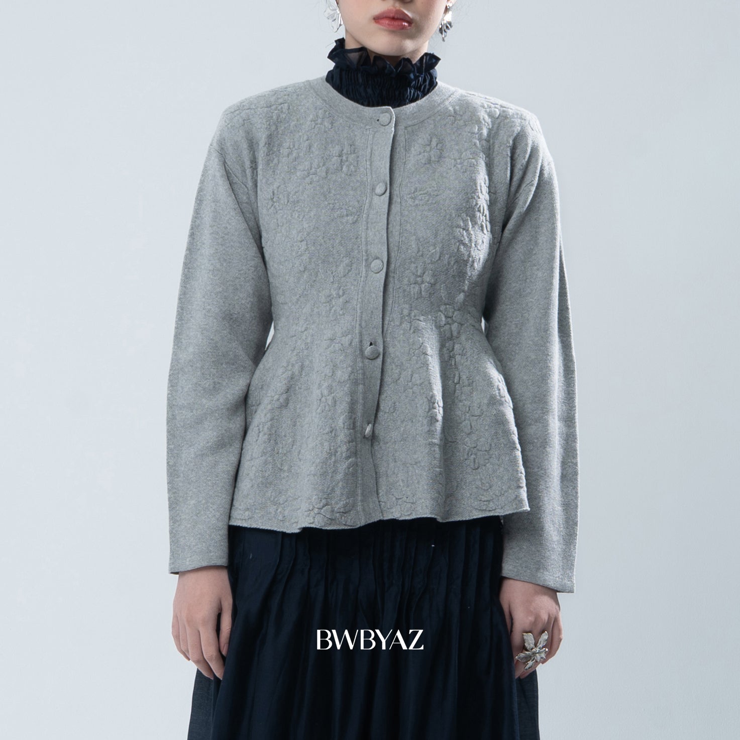 Grey textured knit cardigan worn by a person on a light gray background, with 'BWBYAZ' branding.