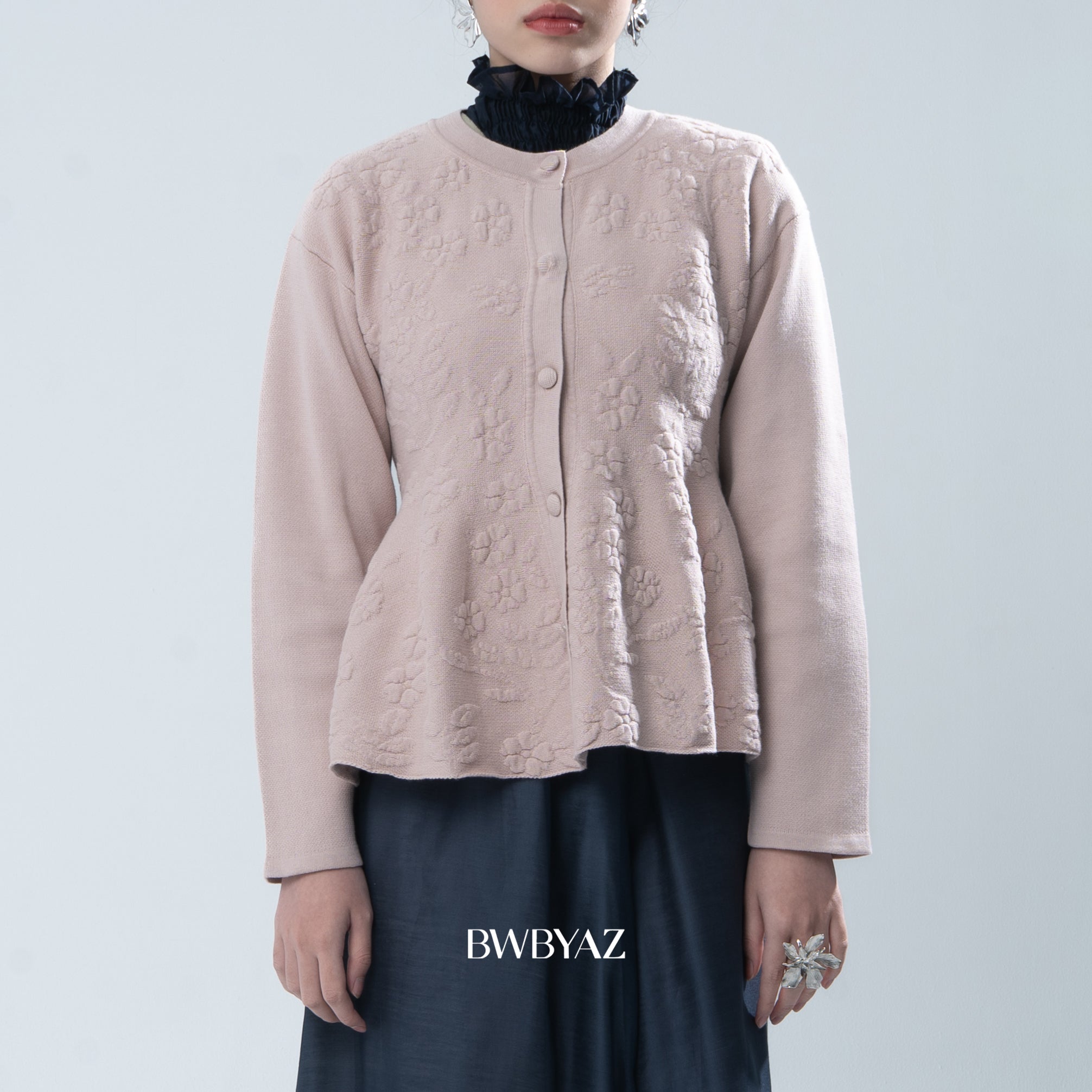 Light pink textured knit cardigan worn by a person on a light gray background, with 'BWBYAZ' branding.