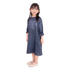 A navy blue girl's tunic with a crinkle silk material, displayed on a young model.