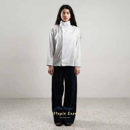 Person wearing a white and blue striped shirt by BWBYAZ and black pants on a plain background.