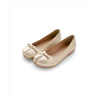 Pair of champagne-colored tabi flat shoes by Cajsa with a bow on a white background