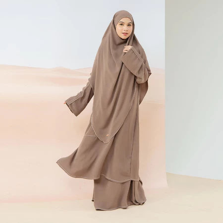 A woman wearing a brown Lozy Hijab abaya set, which includes a long dress and a matching khimar.