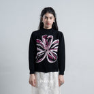 Woman wearing a black cardigan by BWBYAZ with a floral design on a plain background
