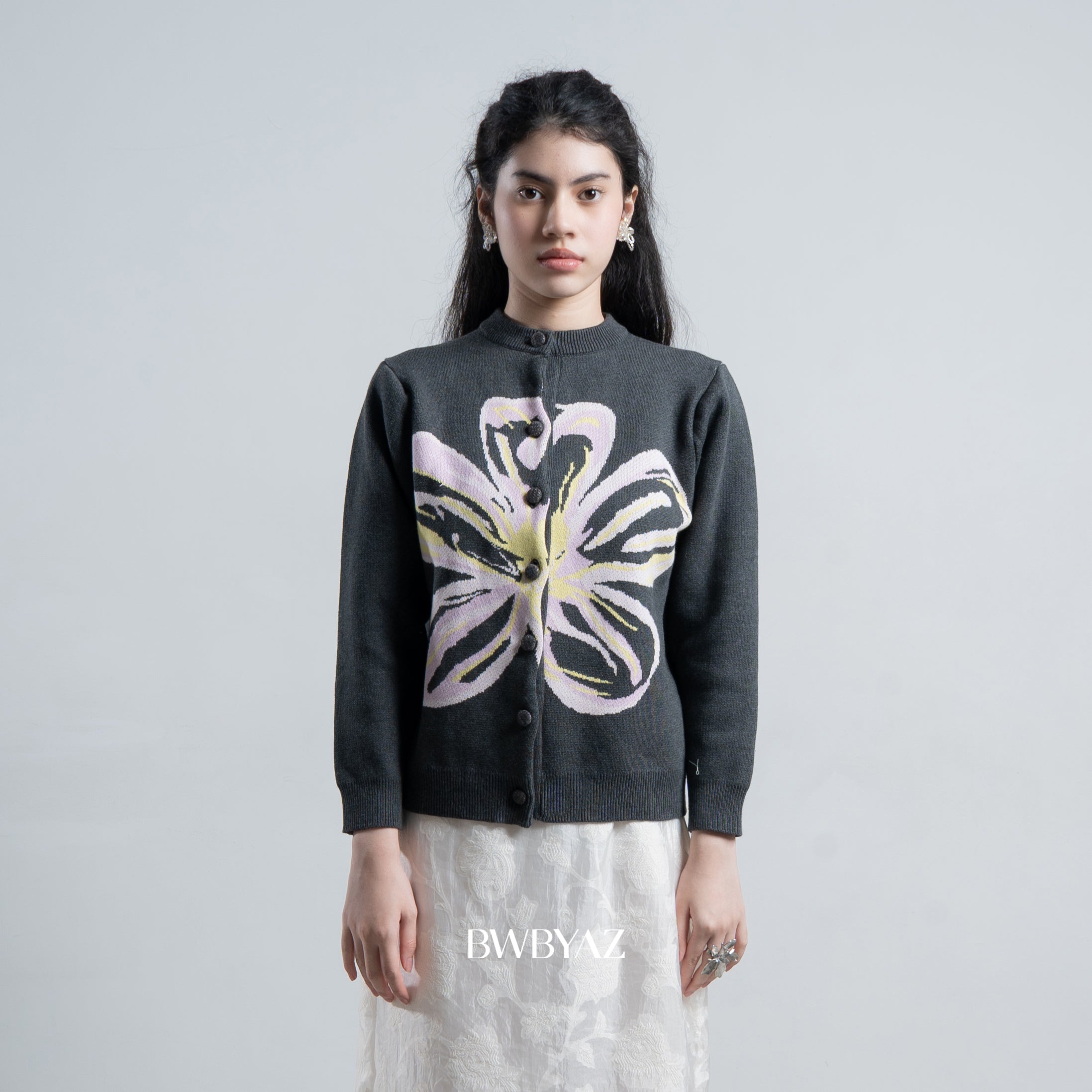 Person wearing a dark grey cardigan by BWBYAZ with a floral design on a plain background