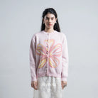 Person wearing a pink cardigan by BWBYAZ with a floral design on a plain background