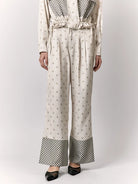 Person wearing a cream-colored outfit with patterned pants by Studio Tui on a white background