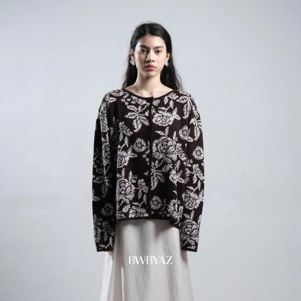 Woman wearing a dark brown floral patterned cardigan by BWBYAZ against a plain background