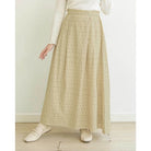 Person wearing a butter-colored patterned skirt by Mistyvori with a white top on a light wooden floor.