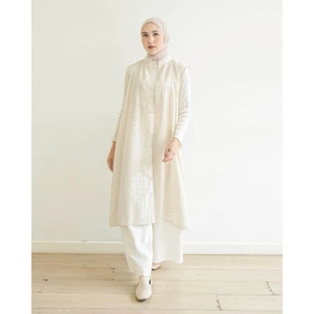 Woman wearing a long white vest by Mistyvori over white inner with a hijab against a white background