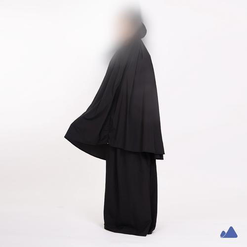 Black prayer hijab with a draped design from Muhajir Project on a white background