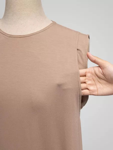Light brown sleeveless top on a mannequin with a hand pointing to it, against a gray background