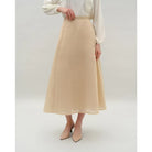 Person wearing a beige skirt by Kasa Heritage and white blouse on a plain background