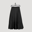 Black skirt by Maima on a hanger against a light gray background