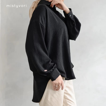 Person wearing a black shirt by Mistyvori with beige pants on a plain background