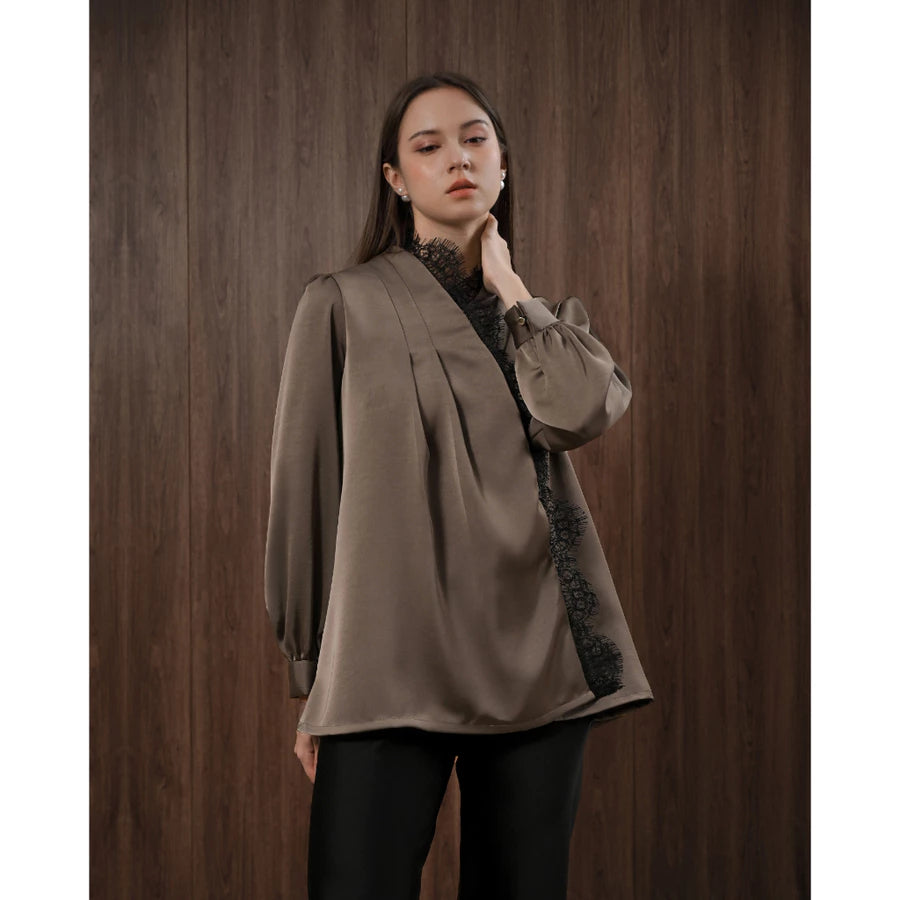 Woman wearing a brown blouse with black lace details by Kasa Heritage against a wooden background