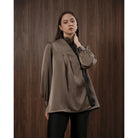 Woman wearing a brown blouse with black lace details by Kasa Heritage against a wooden background