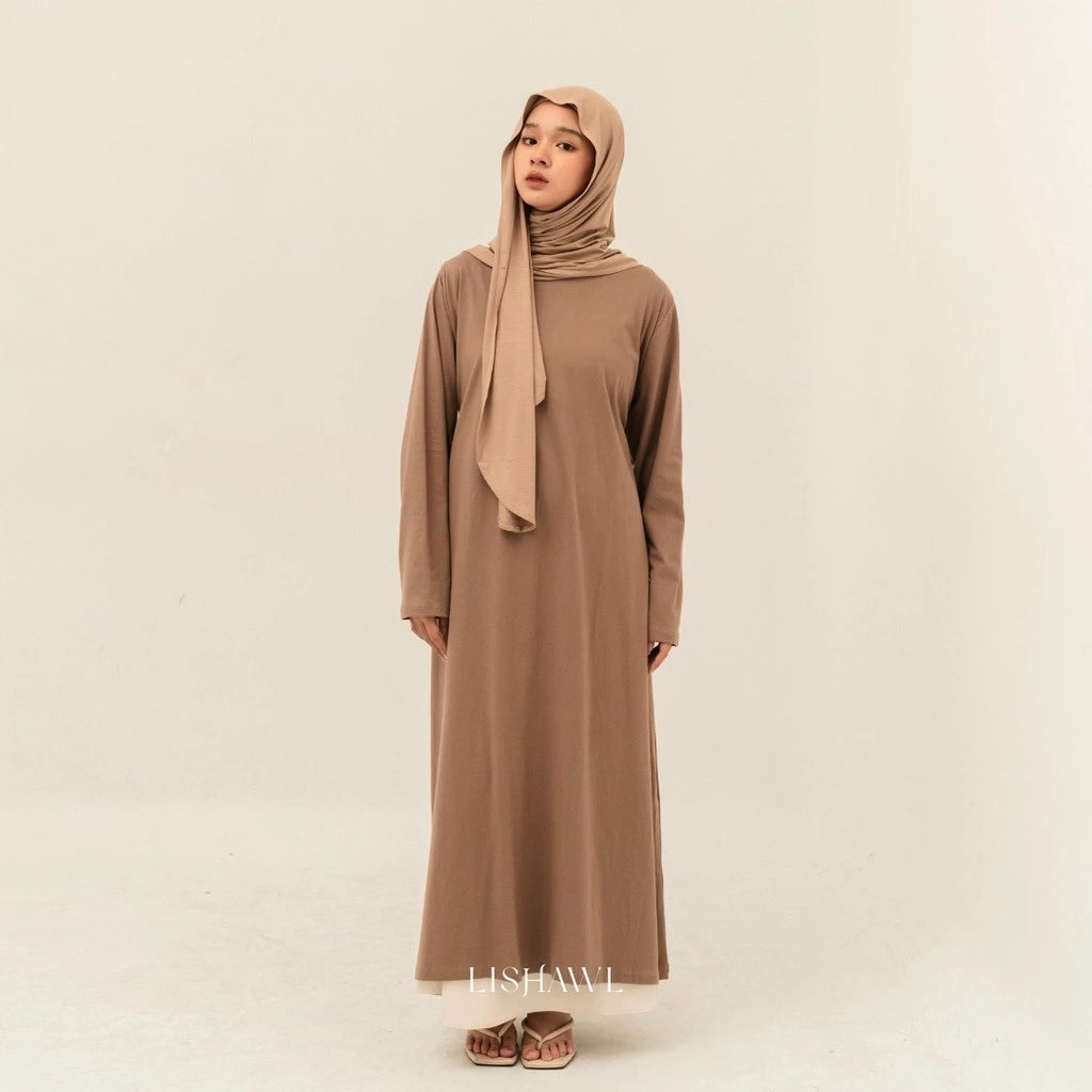 Woman wearing a light brown dress by BWBYAZ and hijab on a beige background