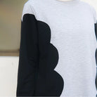 Gray sweater with black scalloped arm designs by Casa Elana on a neutral background