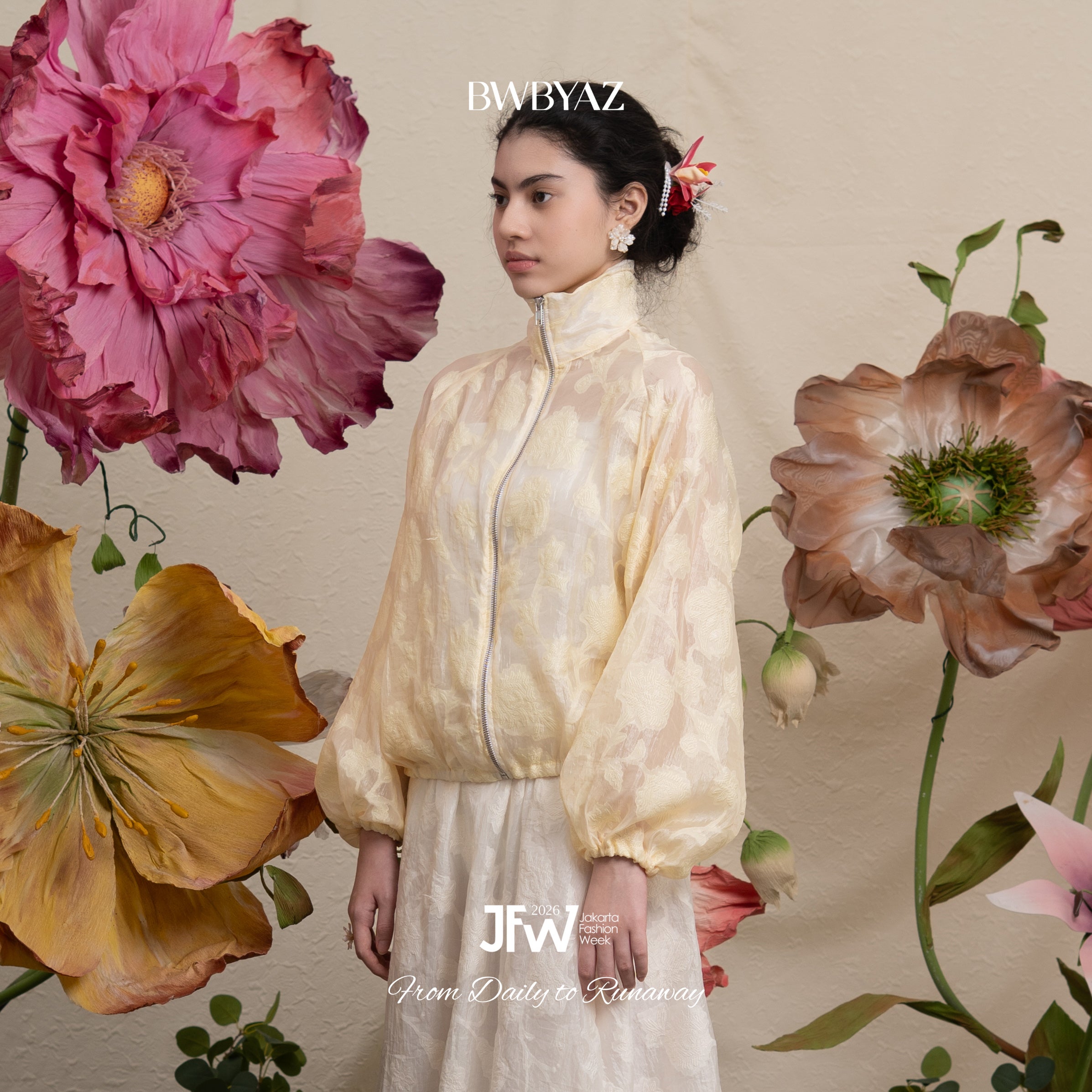 Woman in a light-colored floral-patterned lace jacket with large flowers on a background, featuring the brand 'BWBYAZ'.