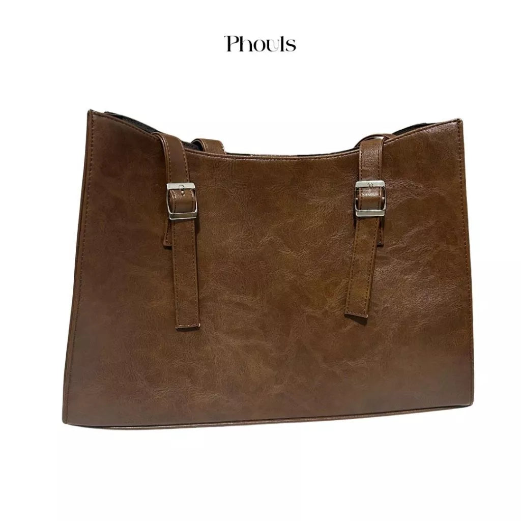 A dark brown shoulder bag with double handles and a debossed logo of Phouls.
