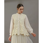 Woman wearing a light yellow blouse with lace detailing by Kasa Heritage on a gray background