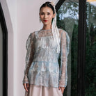 Woman wearing a light blue sheer floral outer by Holy Peony indoors.
