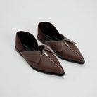 A pair of dark brown leather pointed-toe flat shoes with silver-tone zipper details across the vamp by Cekhas, displayed on a light gray background.