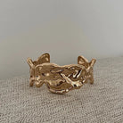 Gold bracelet by Darje on a textured surface with a neutral background