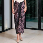 Person wearing a black patterned skirt by Holypeony standing indoors with a glass door in the background