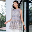 Woman wearing a grey patterned outer by Holy Peony standing in a modern indoor setting.