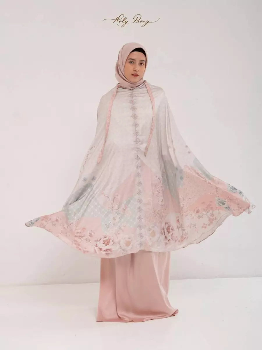 Woman wearing a floral prayer set by Holypeony with a peach-colored accents on a white background