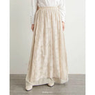 Person wearing a long cream skirt by Mistyvori with a plain background