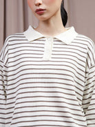 A close-up of a model wearing a long-sleeve polo shirt by Hijabchic with thin brown horizontal stripes on an off-white base, featuring an off-white collar and a three-button placket.