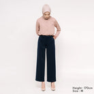 Woman wearing a light pink shirts and black culotte pants from Atala Scarves on a white background