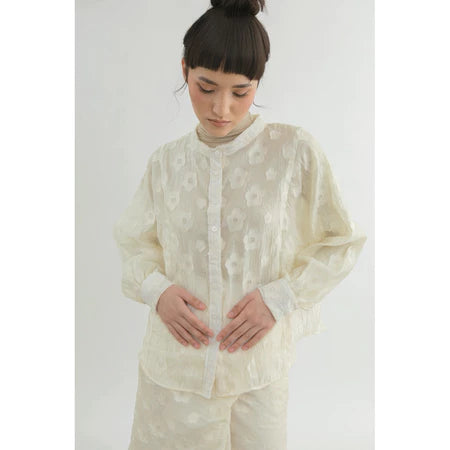 Person wearing a light-colored shirt by Yestoday with a subtle pattern on a white background
