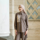 Woman wearing a brown outfit with floral embroidery by Tunique in an indoor setting