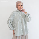 Woman wearing a green striped shirt by Mistyvori and hijab on a plain background