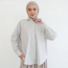 Woman wearing a grey striped shirt by Mistyvori and hijab on a white background
