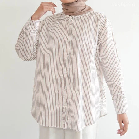 Person wearing a light brown striped shirt by Mistyvori and hijab on a white background