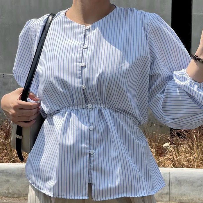 Person wearing a blue striped blouse by BWBYAZ holding a glass against a plain background
