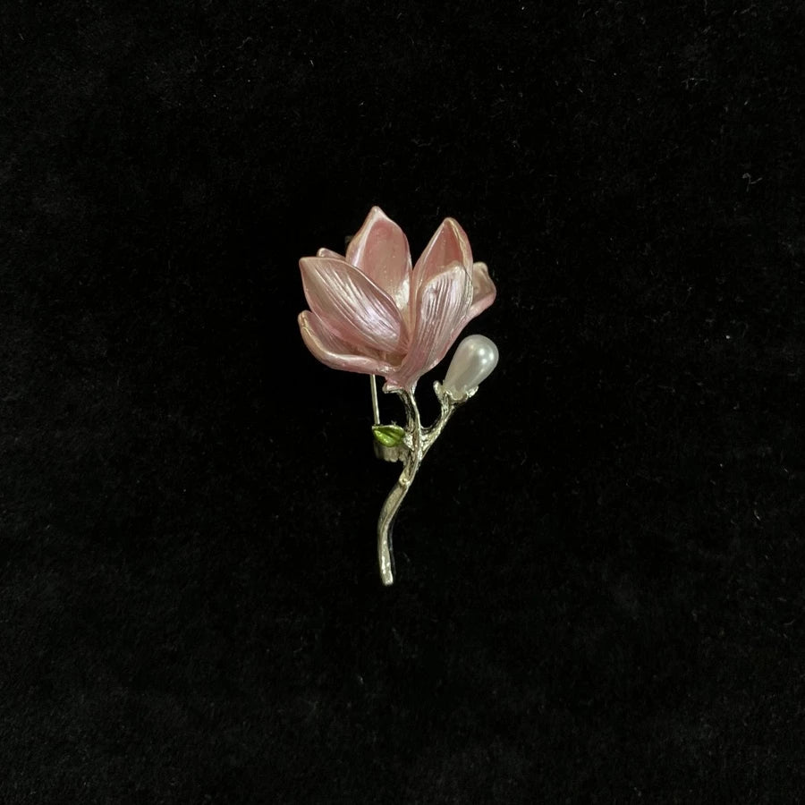 Pink lotus-shaped brooch by Holypeony on a black background