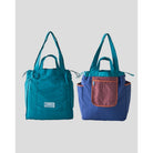 Reversible tote bag by Muhajir Project displayed in two sides, showing dual-color design teal on one side and blue with bronze pocket on the other. This versatile women’s bag features long shoulder straps, side drawstring details, and a functional front pocket, highlighting its practical and stylish two-in-one design.